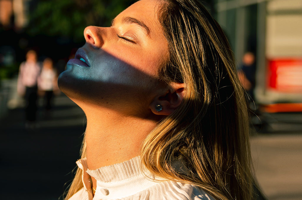 close-up Frau augen zu im abendlichen Sonnenlicht mit refelktion auf dem Gesicht