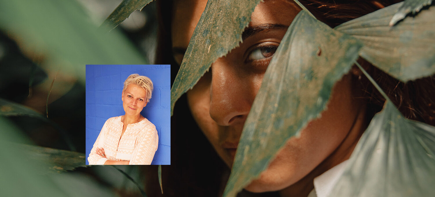 im Hintergrund ein Frauen Gesicht versteckt hinter Blättern.Bild von Marion Müller.
