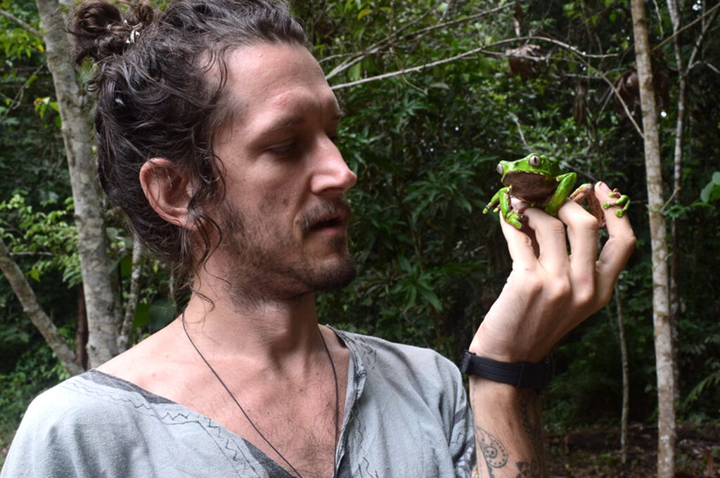 Nic is holding a giant monkey frog, or Phyllomedusa bicolor fin his hands
