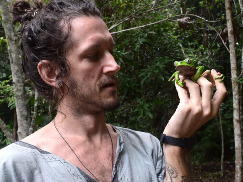 Nic is holding a giant monkey frog, or Phyllomedusa bicolor fin his hands
