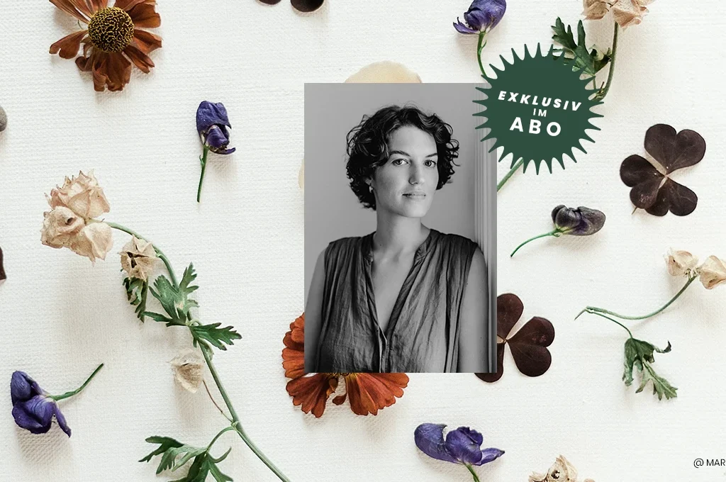Portrait Eva Teja. im Hintergrund getrcoknete Blumen